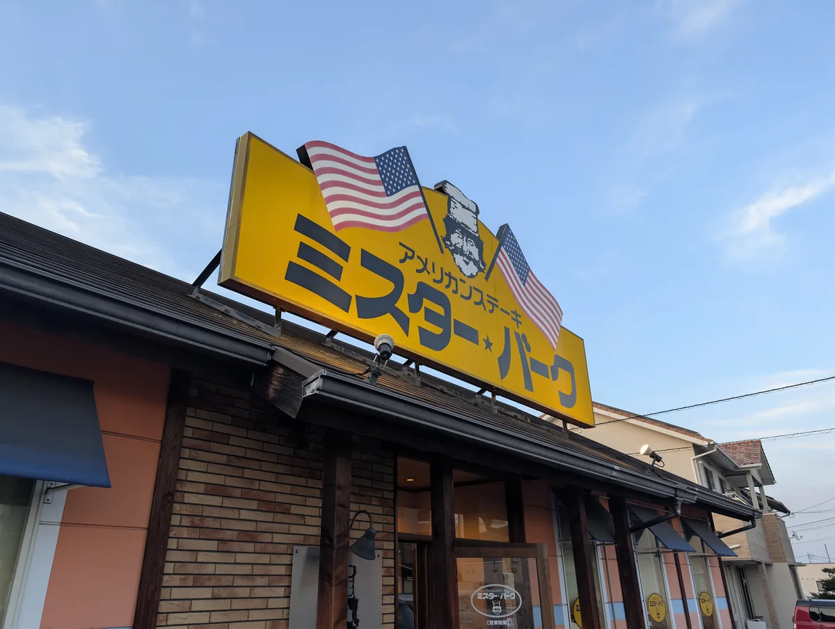 青空の下に立つミスター・バーク総社店の看板