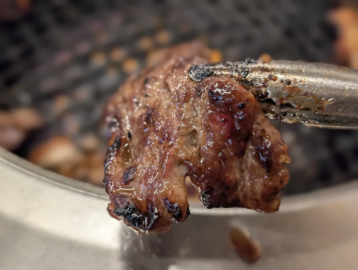 トングで持ち上げた焼きたての肉